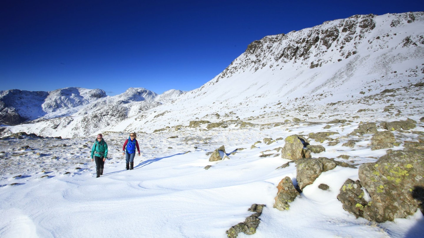 Two hikers in Three Tarns and Scafell range, Lake District in winter