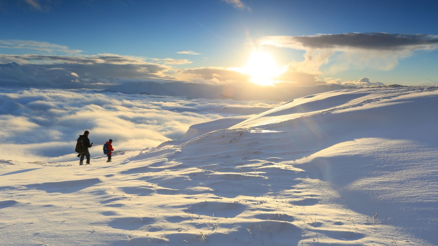 Two hikers with winter sunset at Great Rigg, Lake District