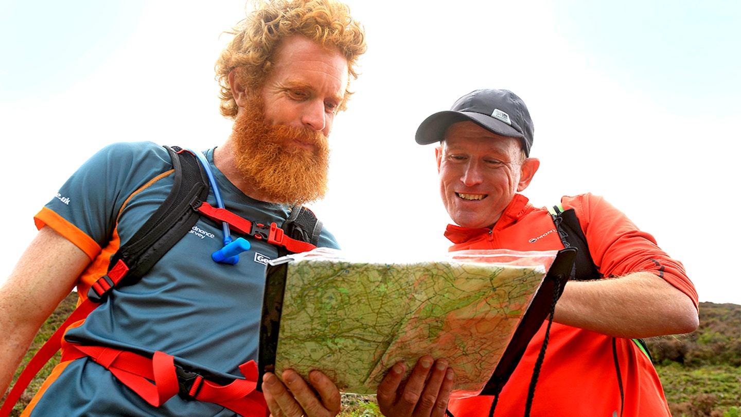 two men look at a map whil trail running