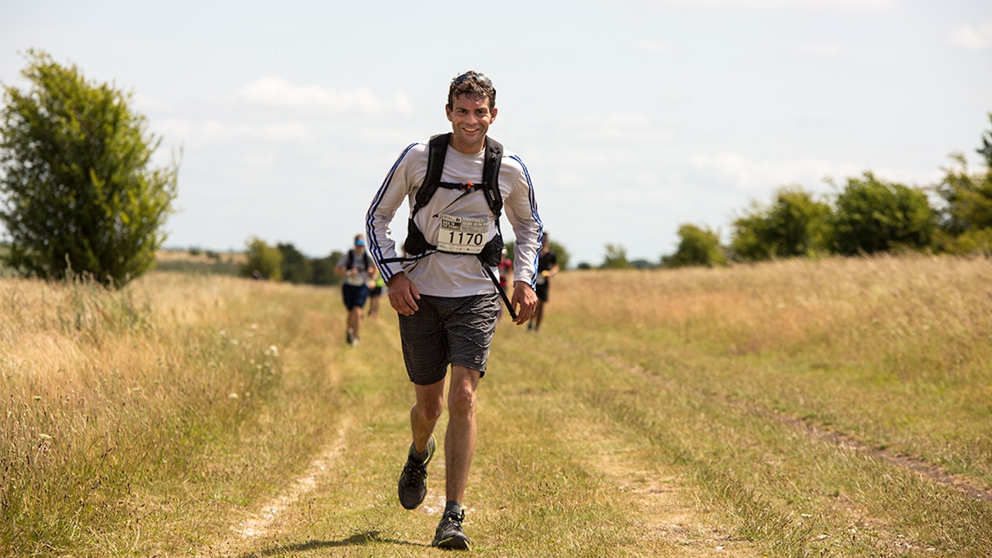 man runs along field in ultra marathon race