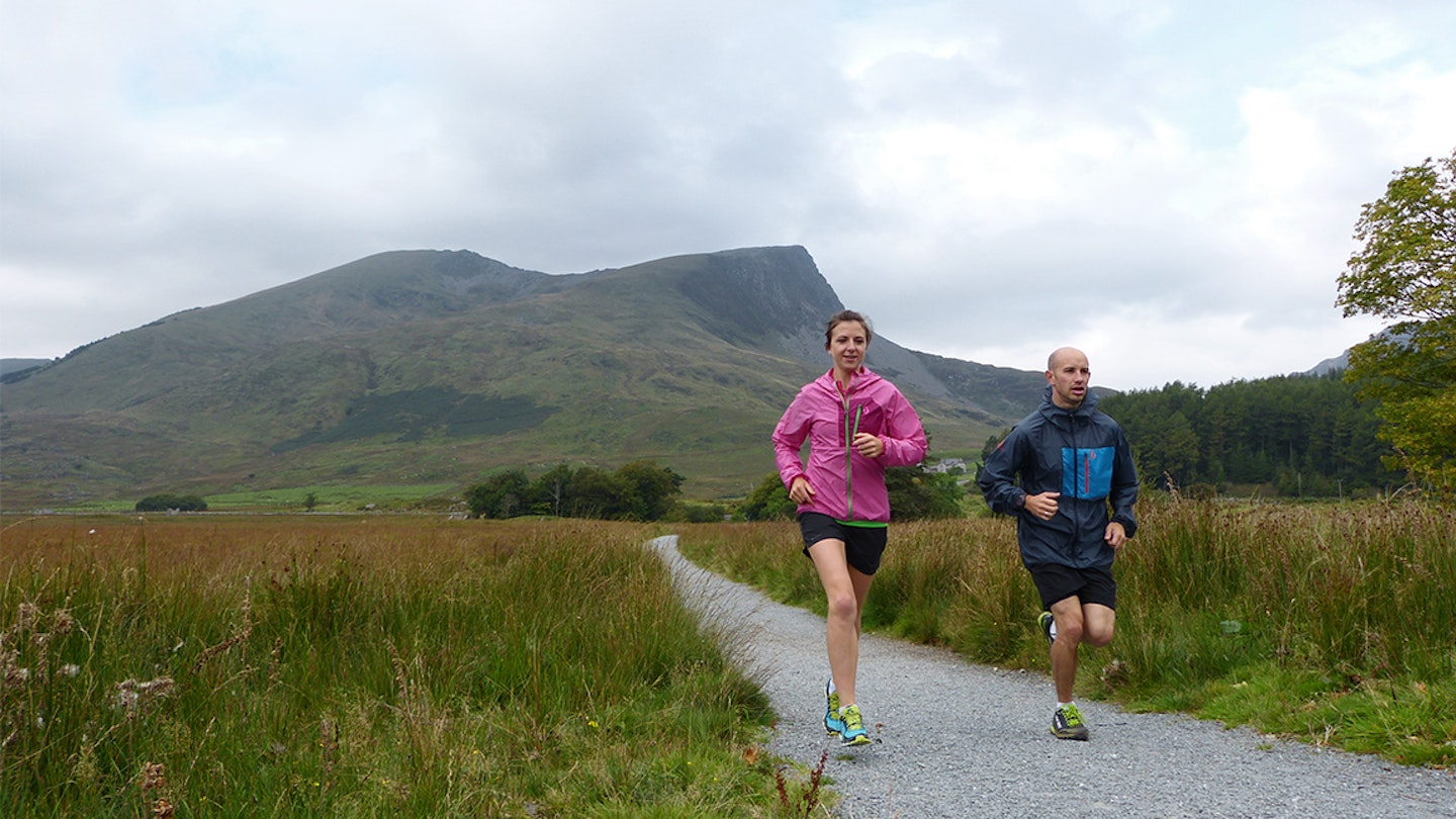 man and woman runs along a gravel path