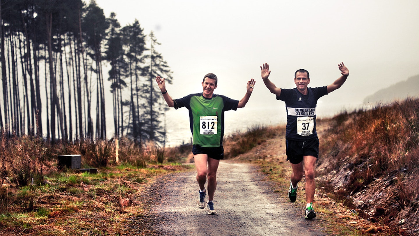 two men run in a muddy trail race