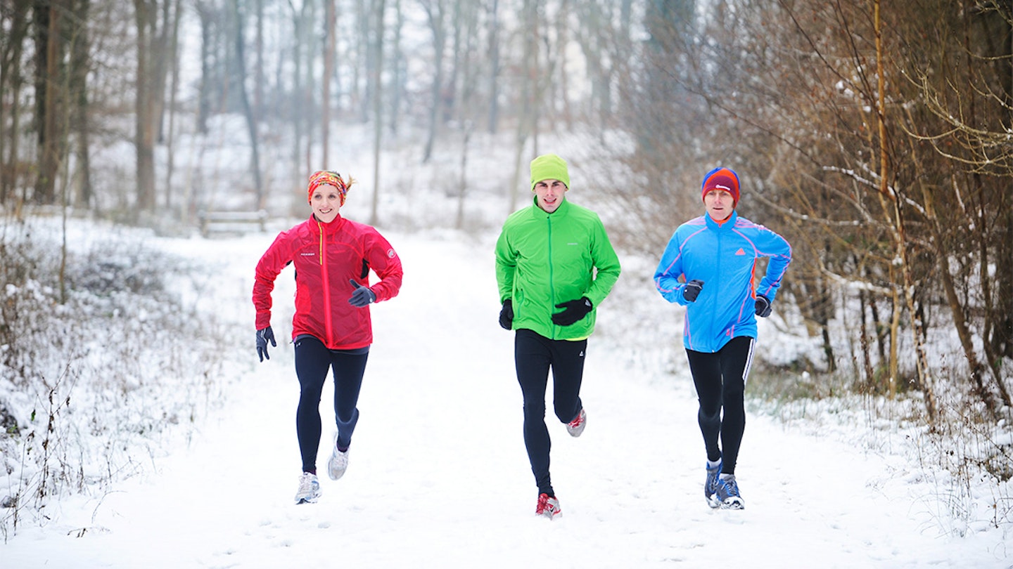 three friends run in the snow