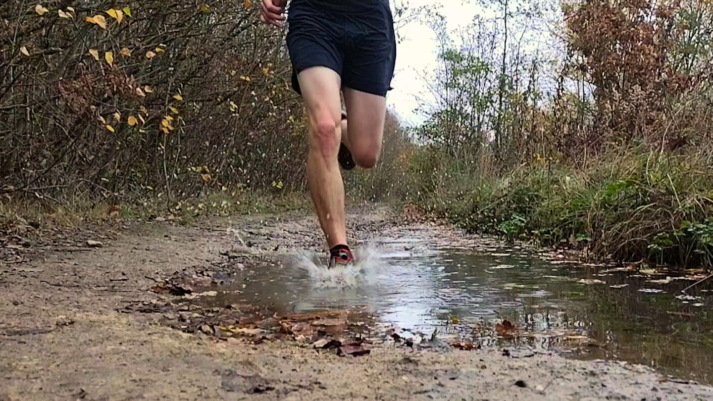 Going through a puddle wearing waterproof trail running shoes