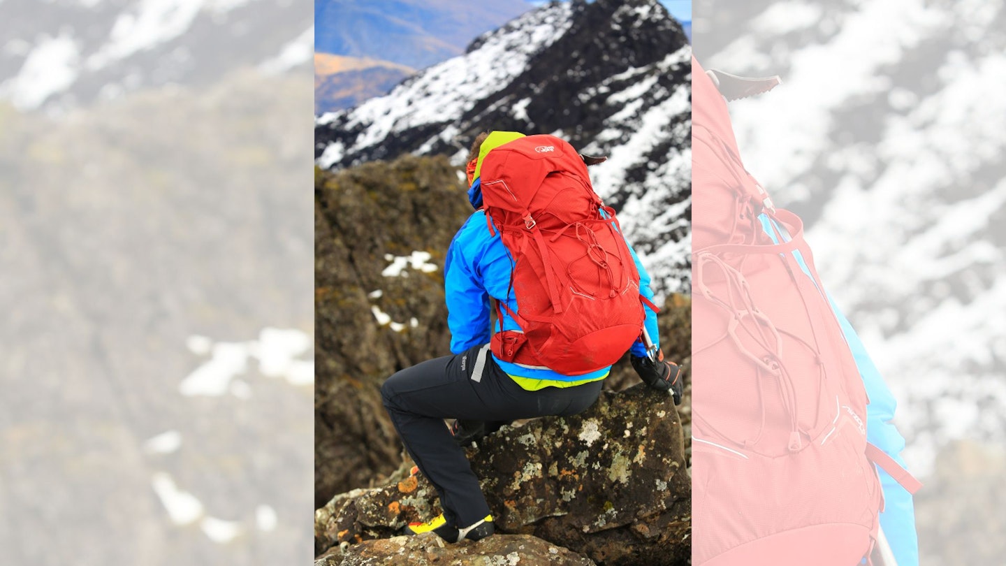 Hiker sitting on the summit ridge of Sgurr Alasdair