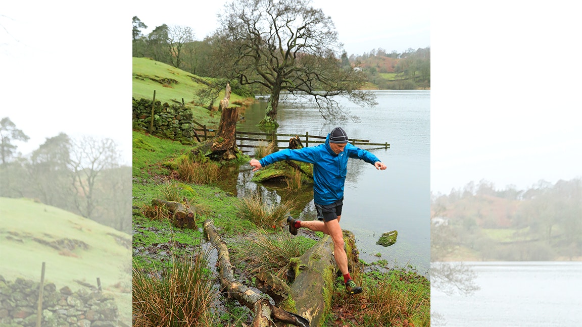 a man jumps down off a rock when trail running