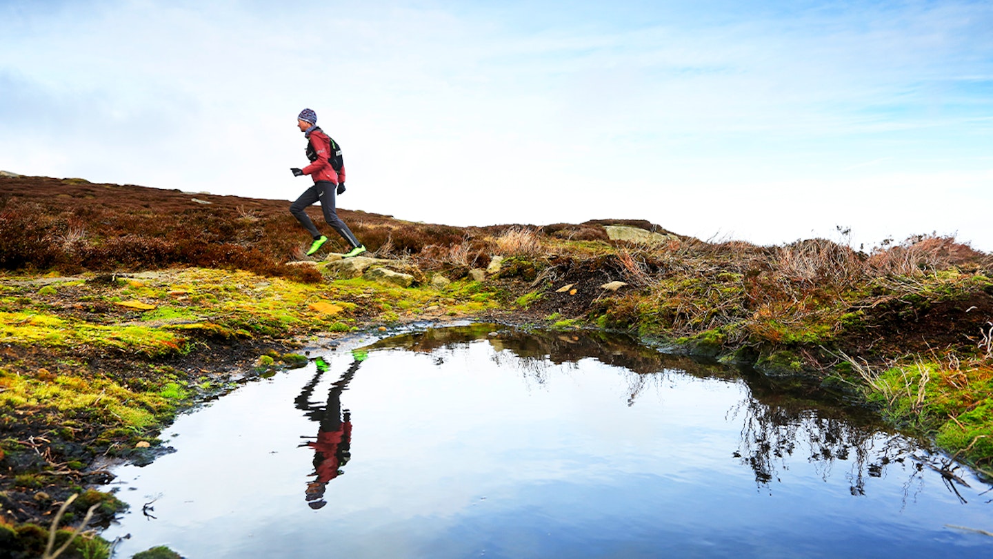 man runs along a lake