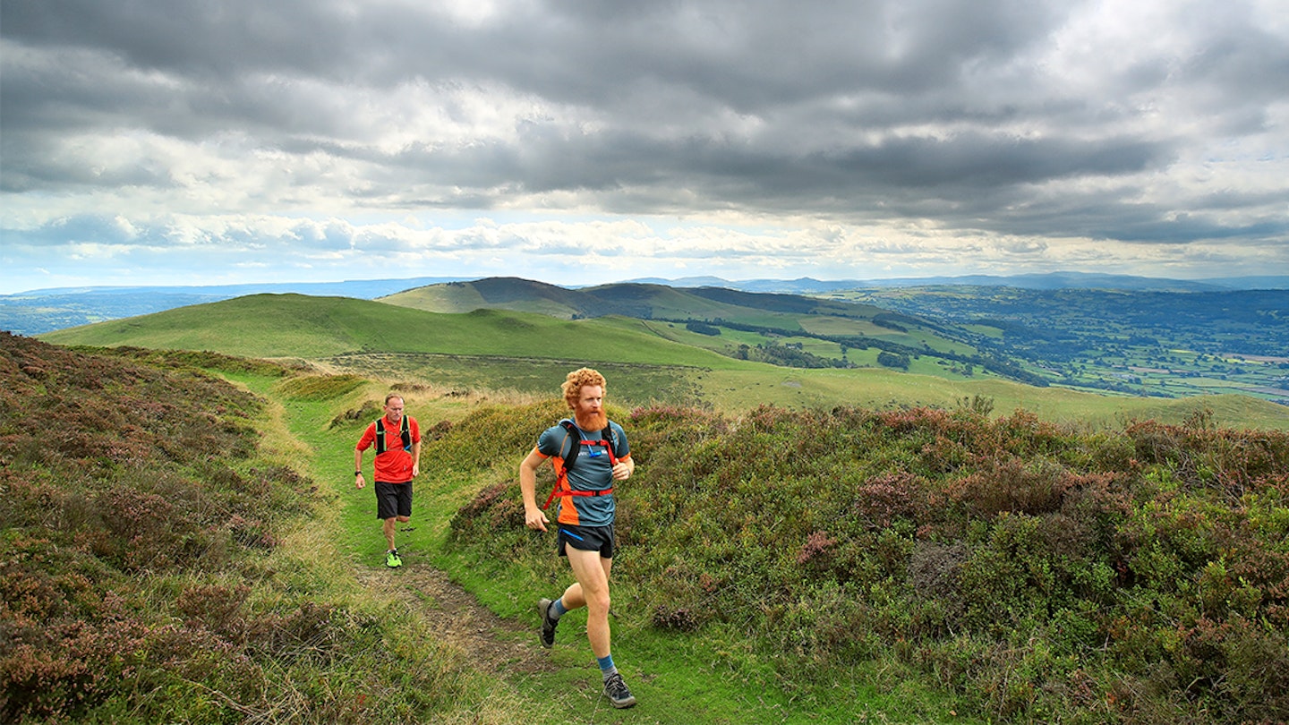 two men run along a trail