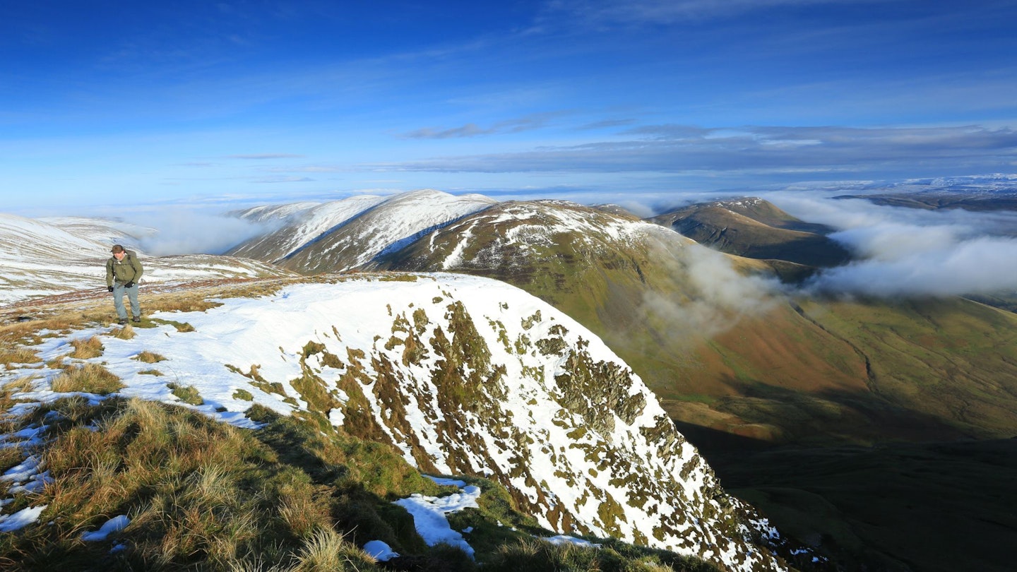 Hiker walking uphill above Cautley Crag