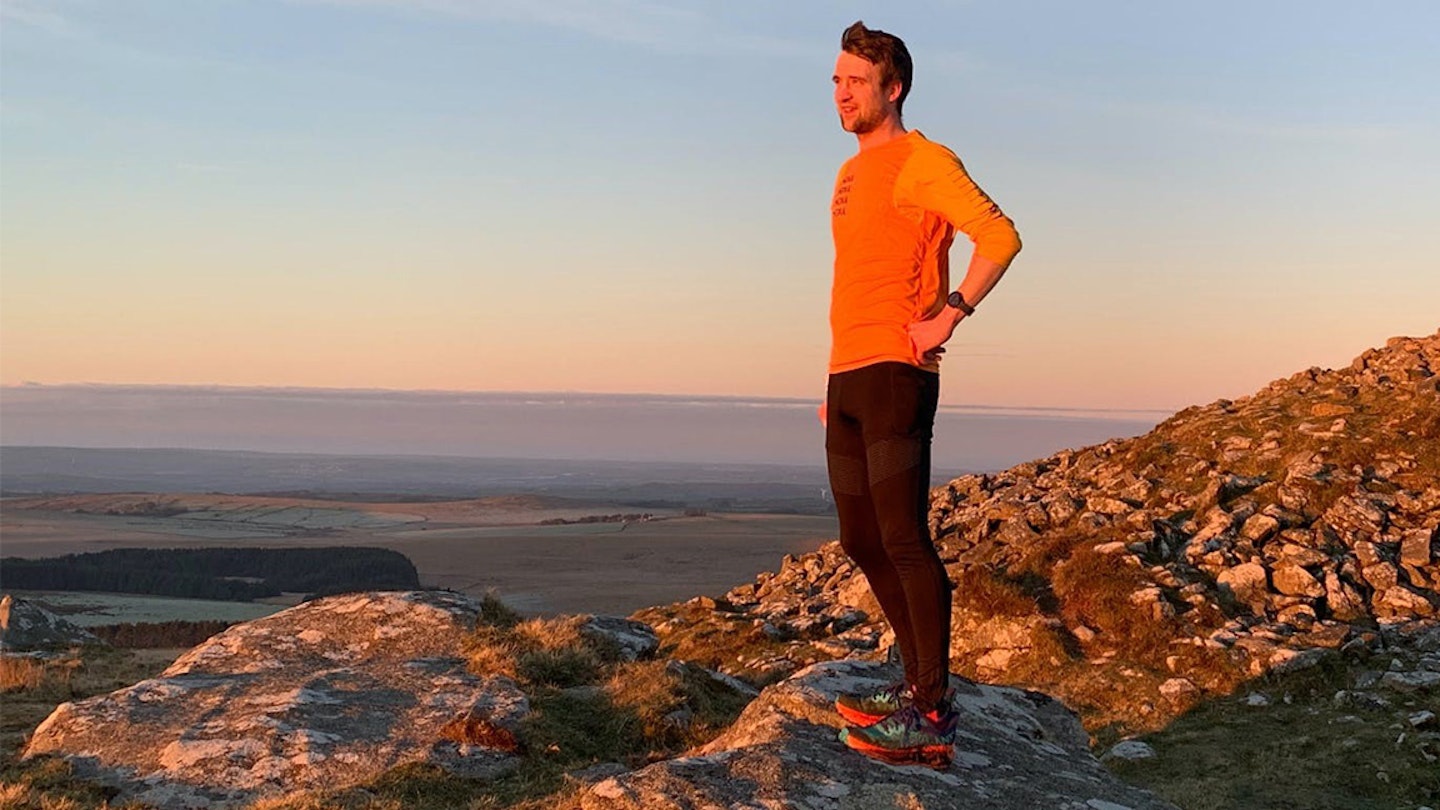 man stands looking a view over mountain