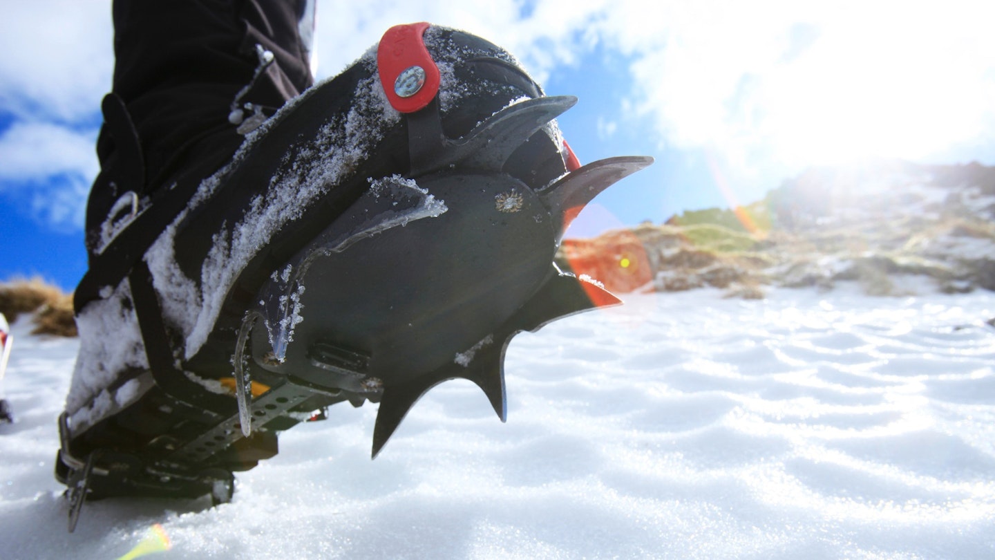 A hiking boot fitted with a crampon