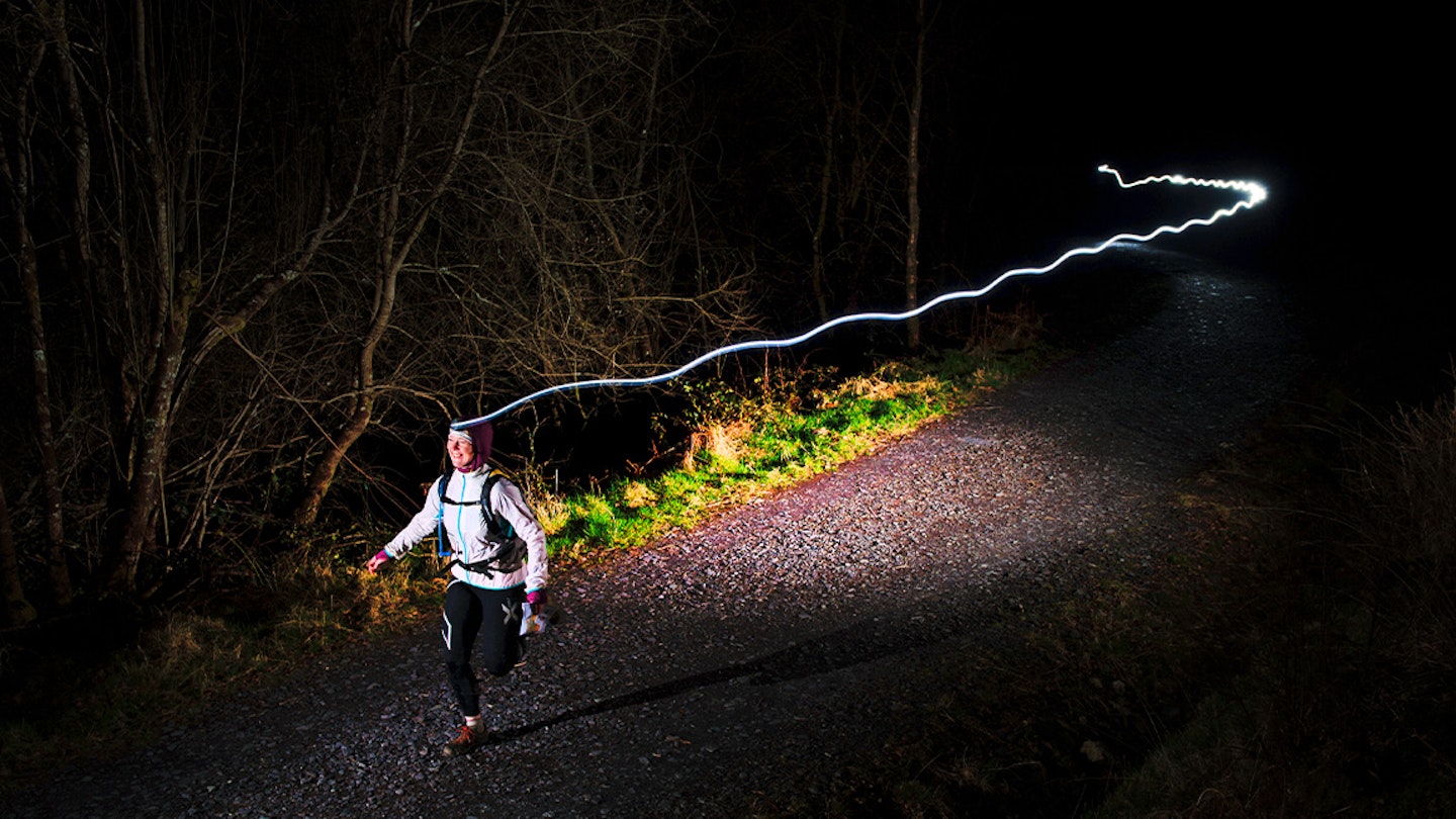 woman runs in the dark with headtorch