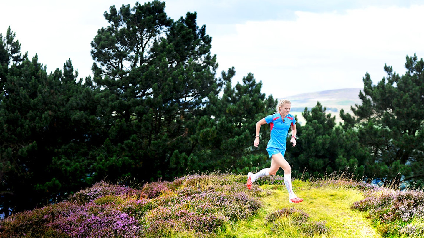 woman runs through gorseland