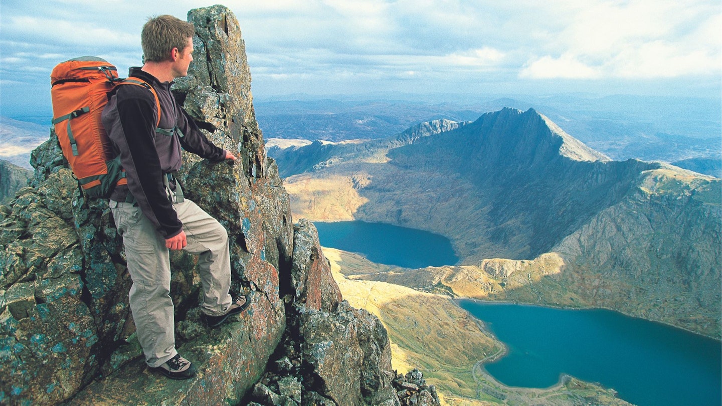 Hiker standing on a rock pinnacle, Snowdon