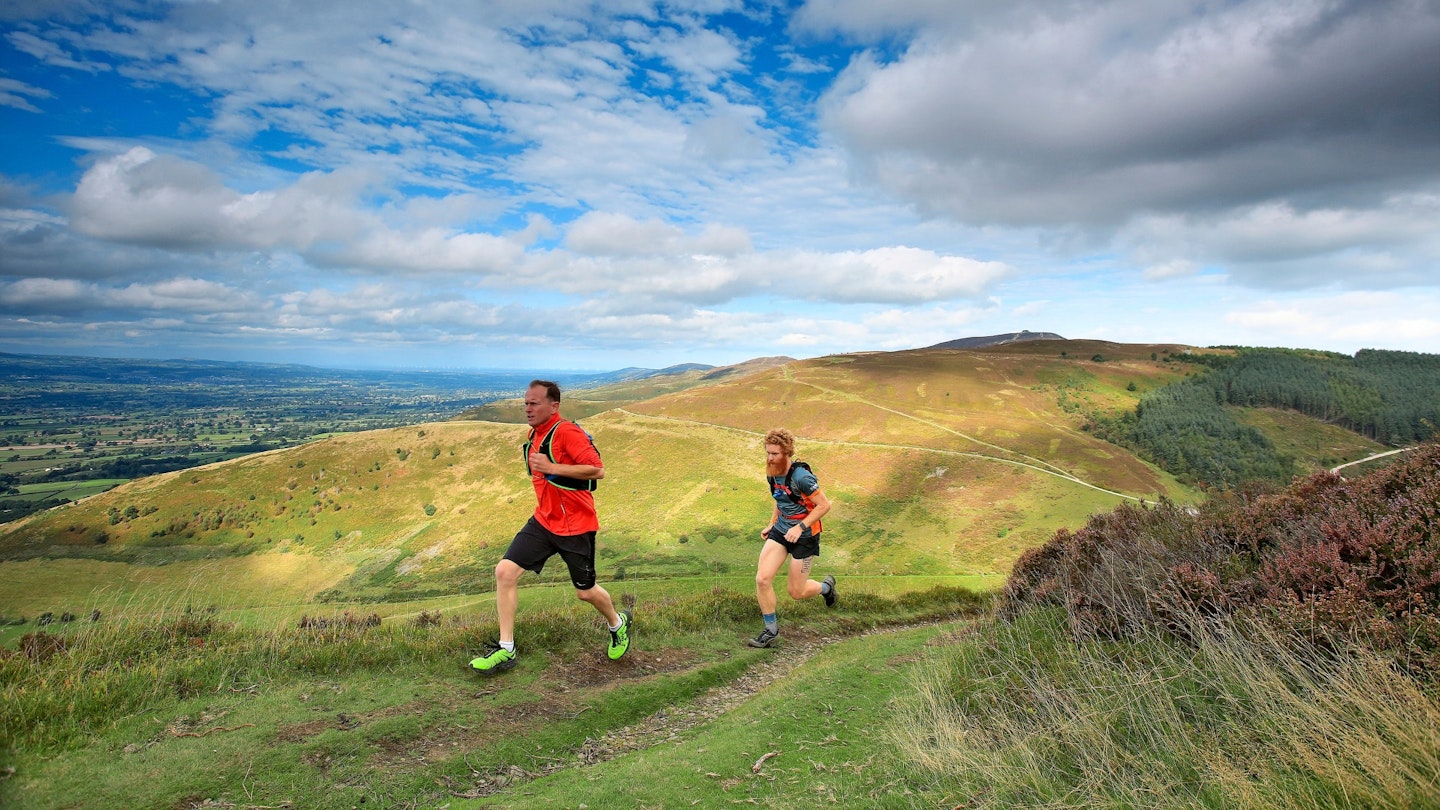 Two men running on hill in North Wales