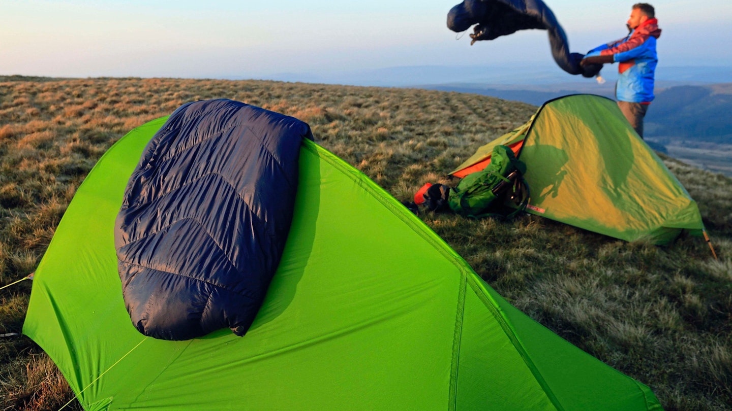 Winter sleeping bag draped over a hiking tent