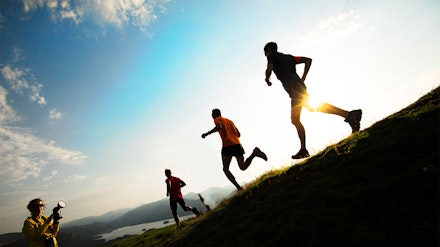 three runners run in a field