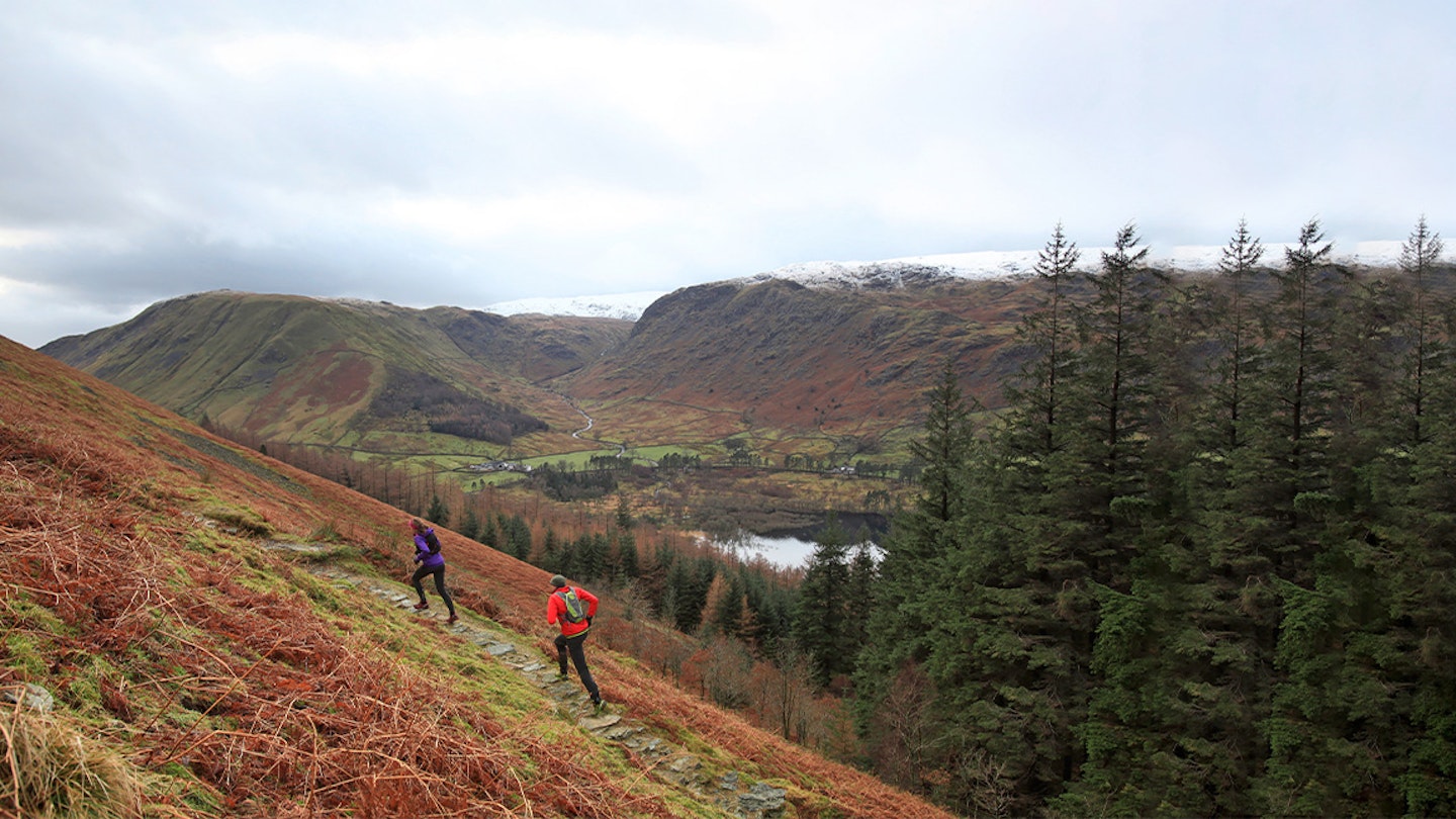 two runners run along a trail in scotland