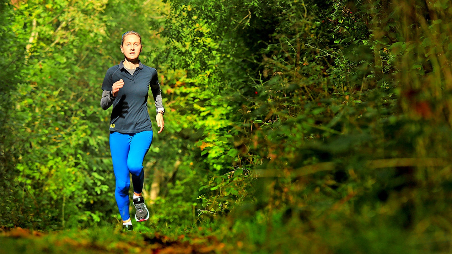 woman runs through a forest