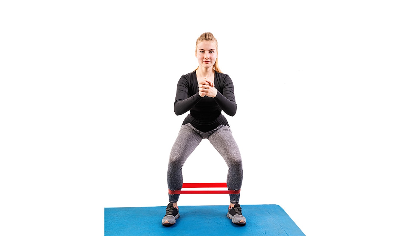 woman does squat with band