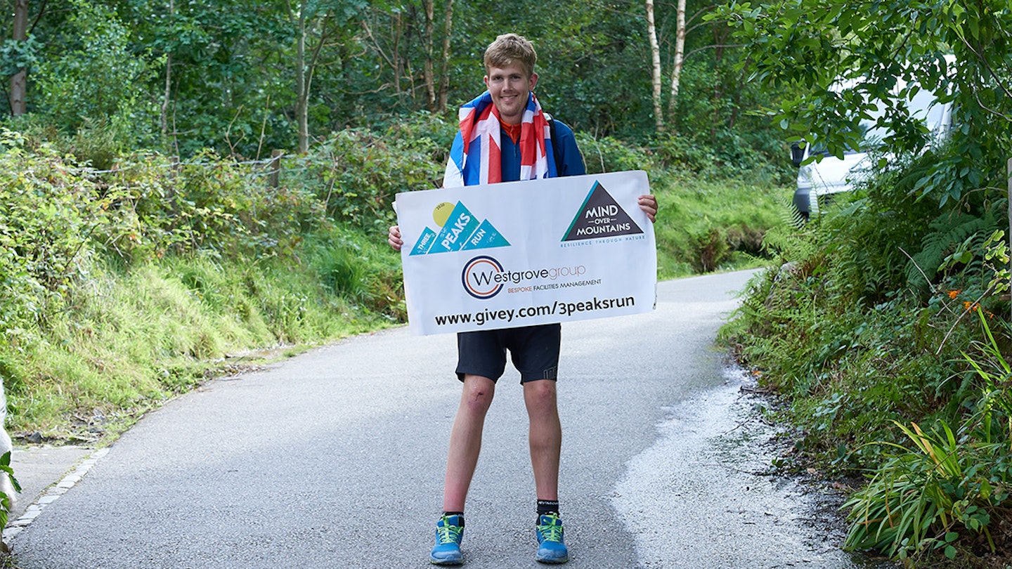 alex holds a sign after completing a challenge