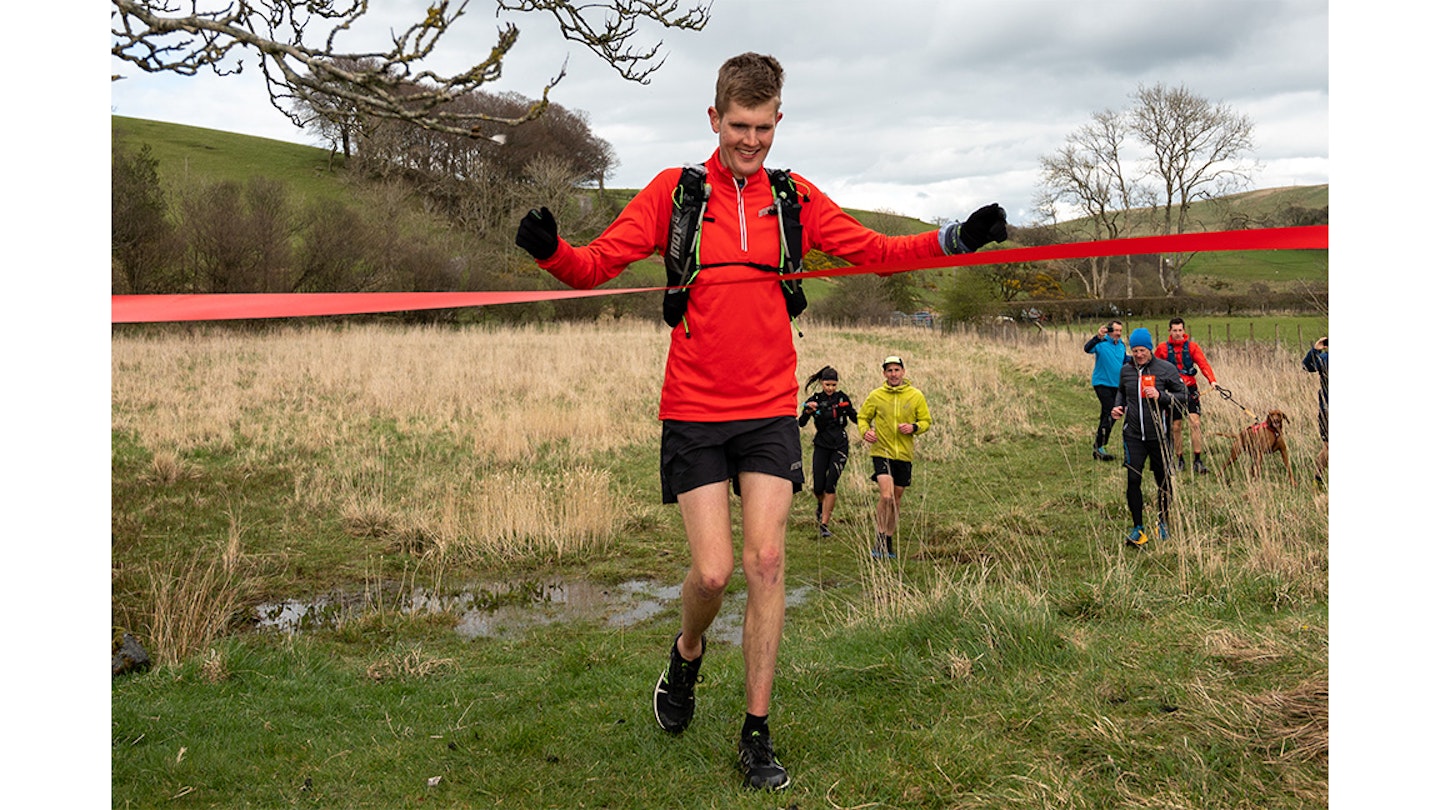 alex taking the tape at the end of a run challenge