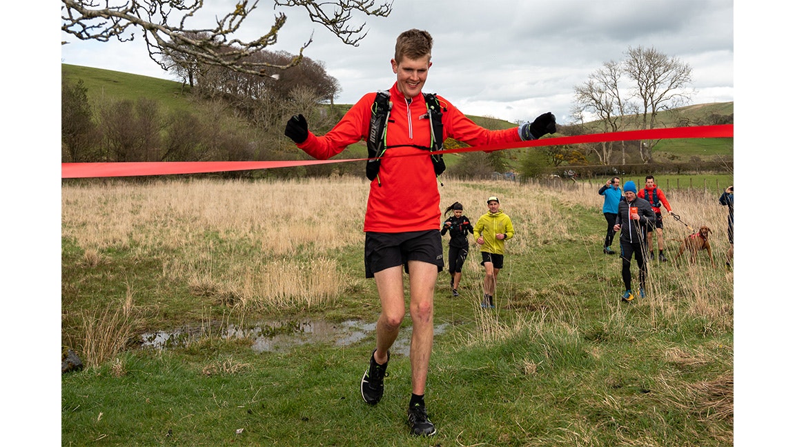 alex taking the tape at the end of a run challenge