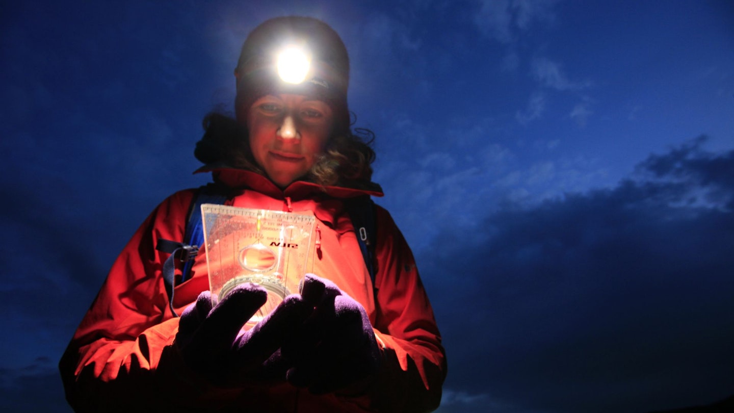 Hiker at night using a compass