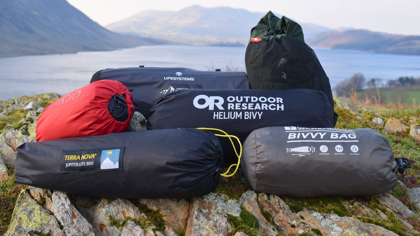 Six bivvy bags in stuffsacks piled together
