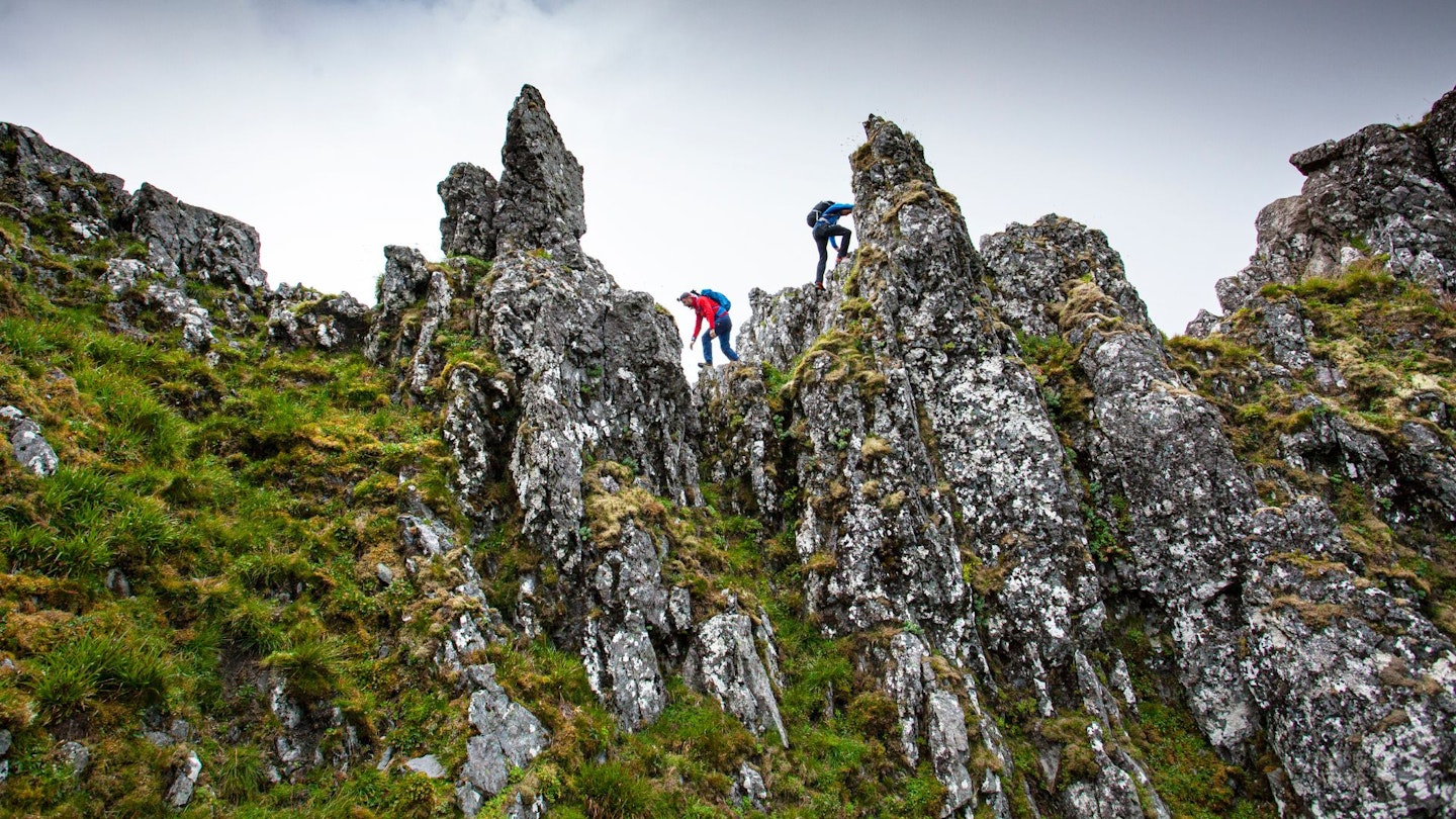 Hikers scrambling pinnacles at Aonach Eagach
