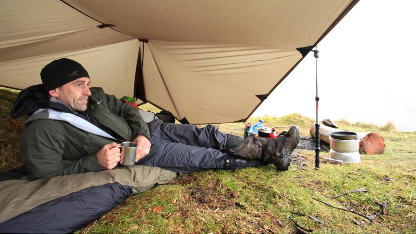 Hiker relaxing in a tarp while camping in the Lake District