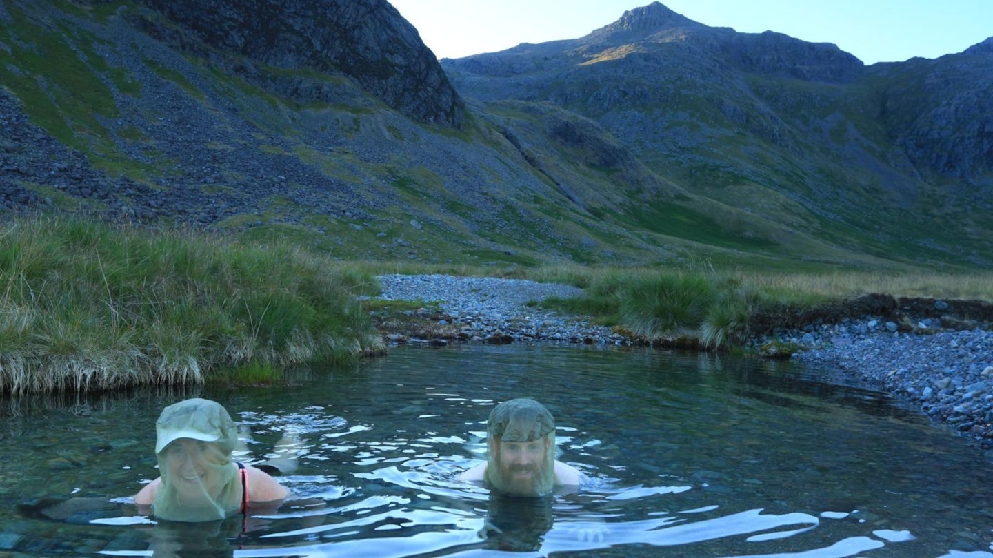 Two hikers wearing midge nets while wild camping in the Lake District