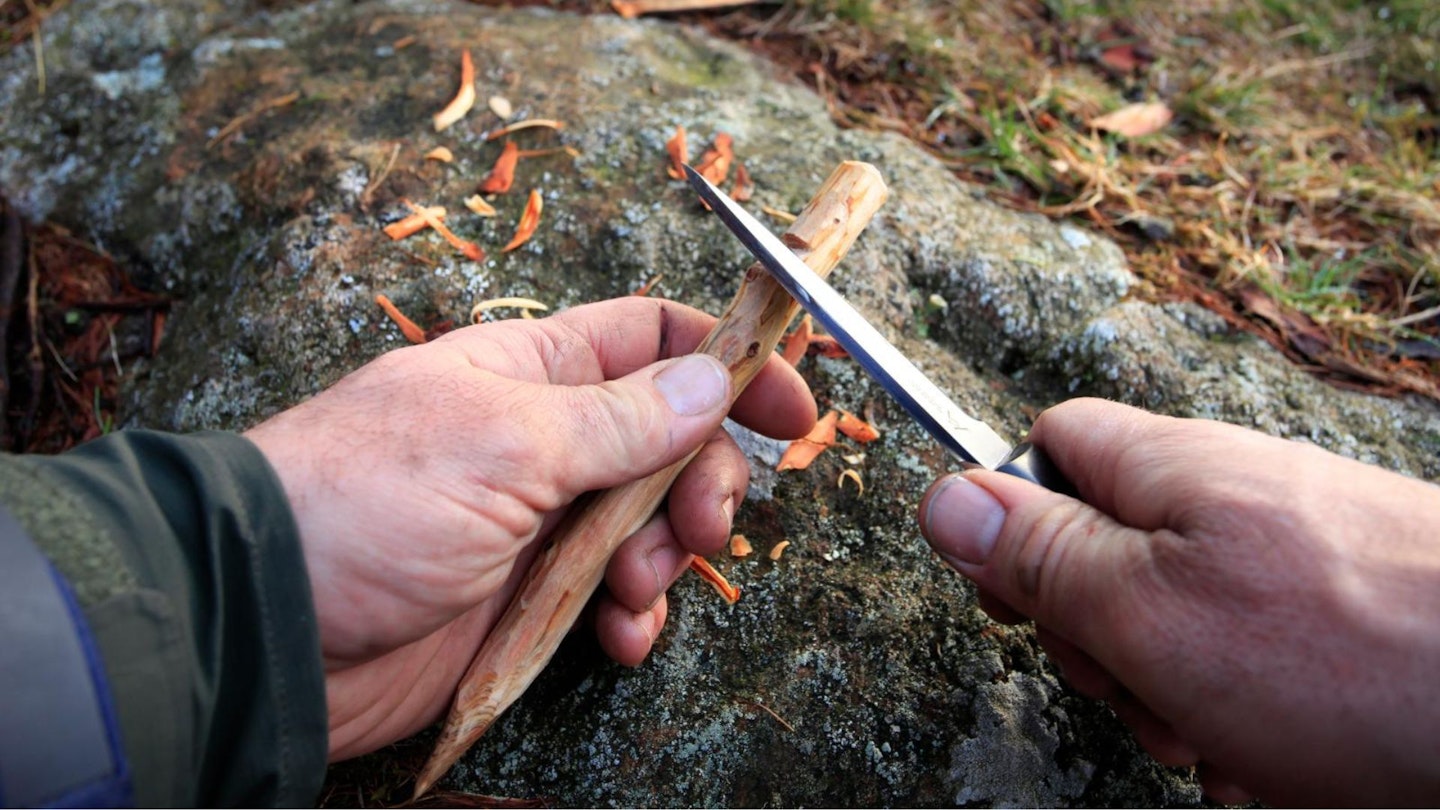 Whittling tent pegs for tarp camping from wood