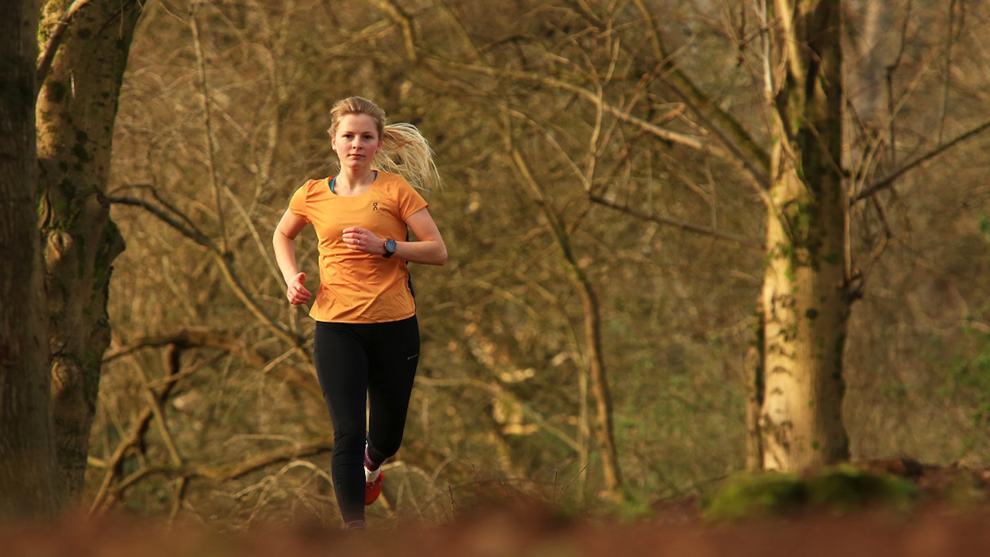 woman runs through a forest