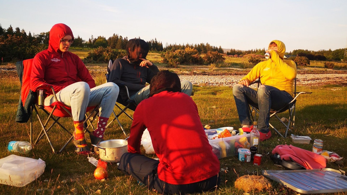 folk cooking outside in midge season