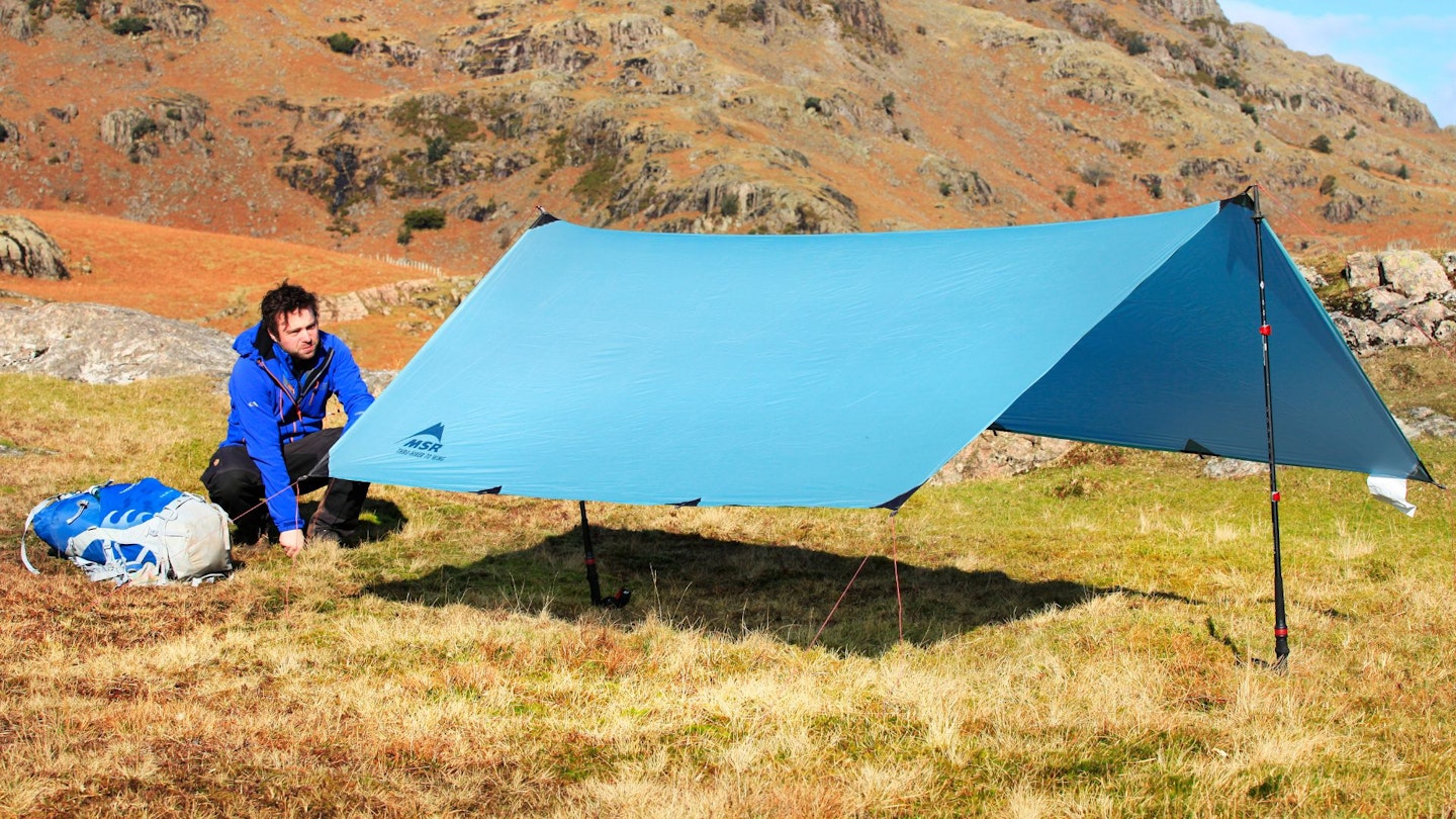 Hiker pitching a tarp