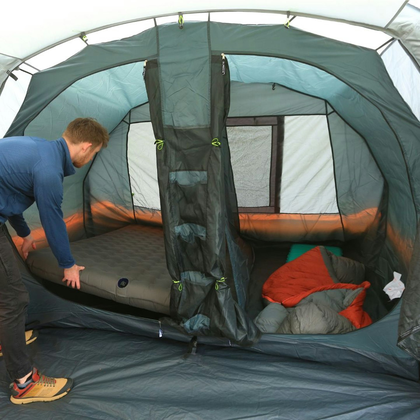 Person putting an airbed into OLPRO Blakedown Breeze 4 bedroom