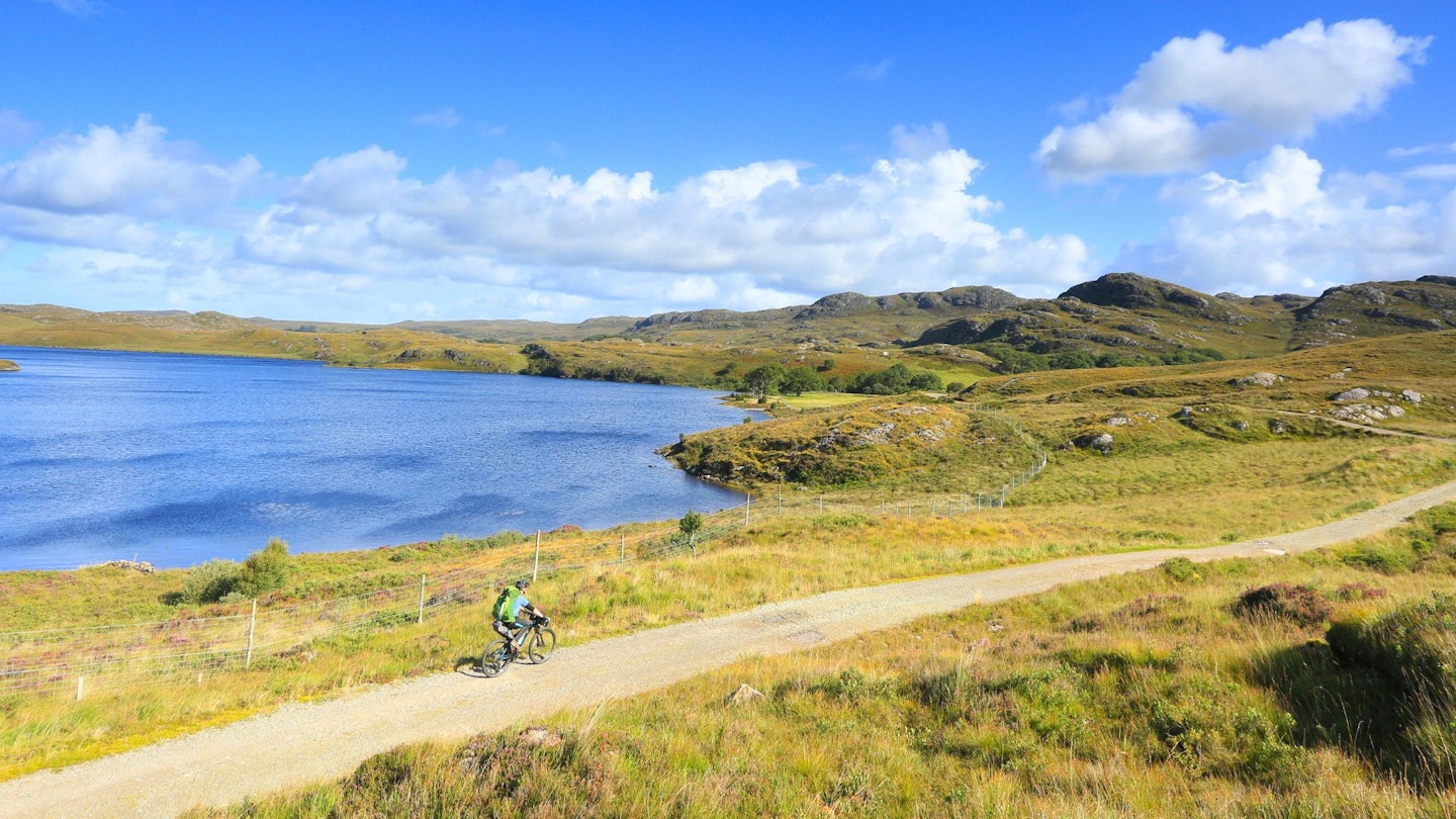 Cycling along gravel track past Loch Kernsary, Scotland