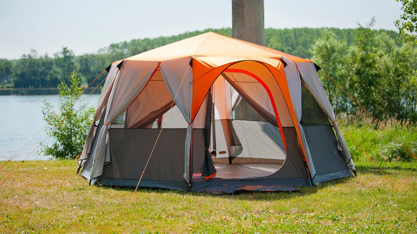 Orange Coleman Octagon 8 tent pitched on the grass
