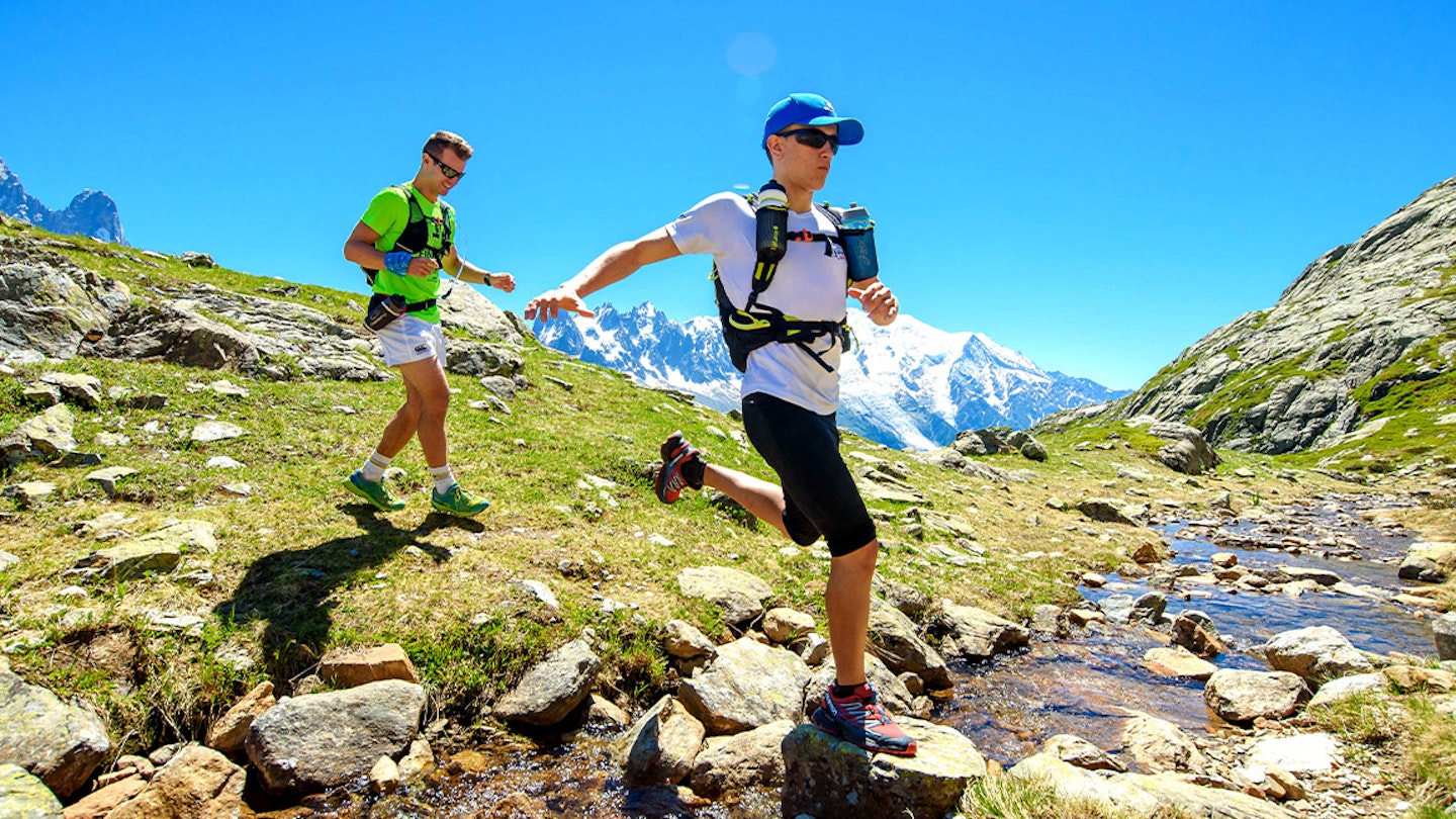 two runners descend a rocky hillside fastpacking