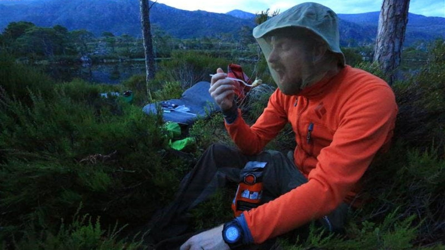 Ben trying and failing to eat while wearing a midge headnet