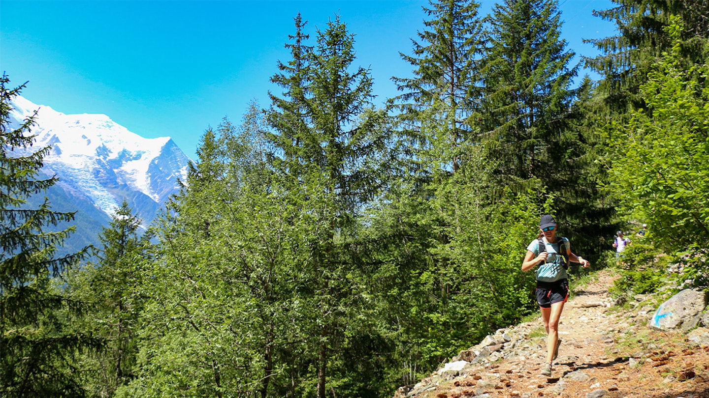 woman runs along a trail in the alps