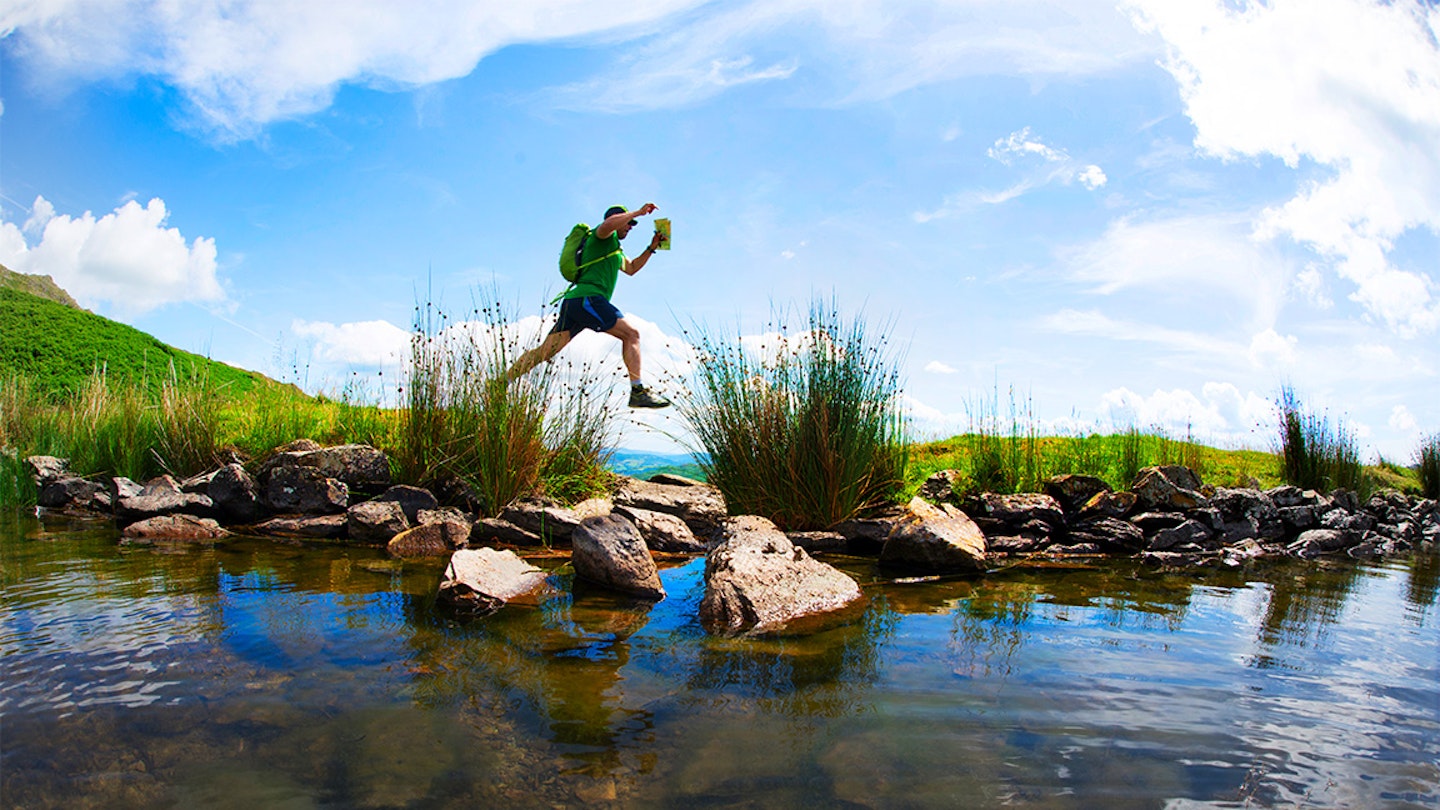 fell running runner jumping over a puddle