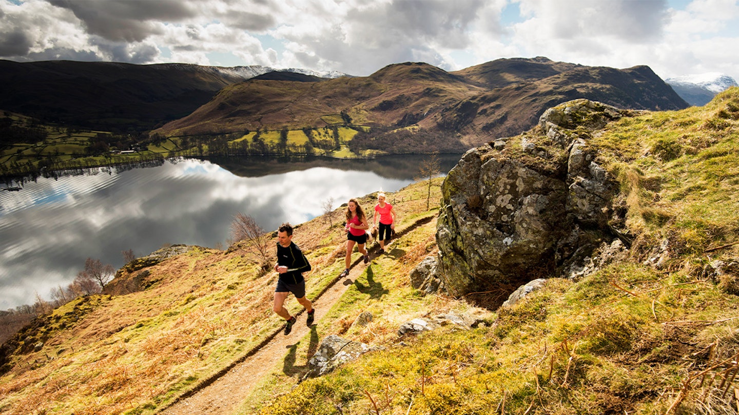 group of runners going past a lake