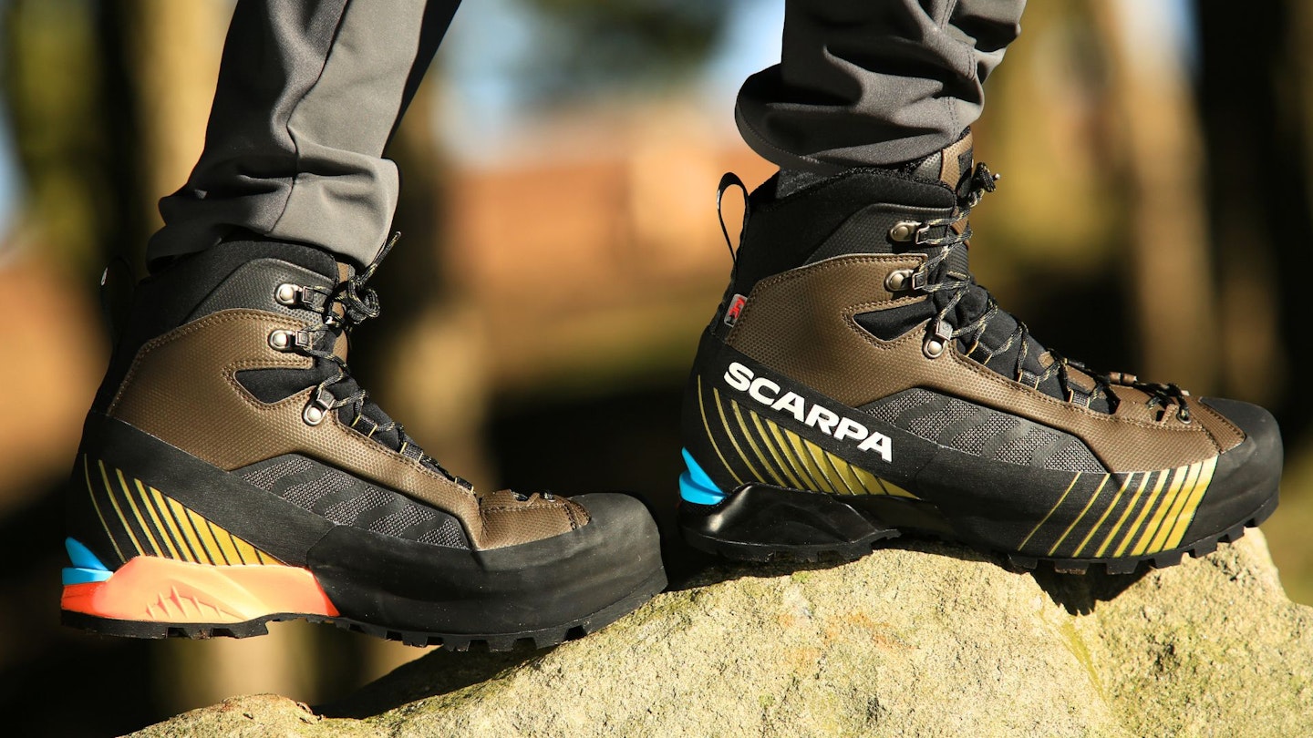 Hiker standing on a rock wearing Scarpa mountain hiking boots