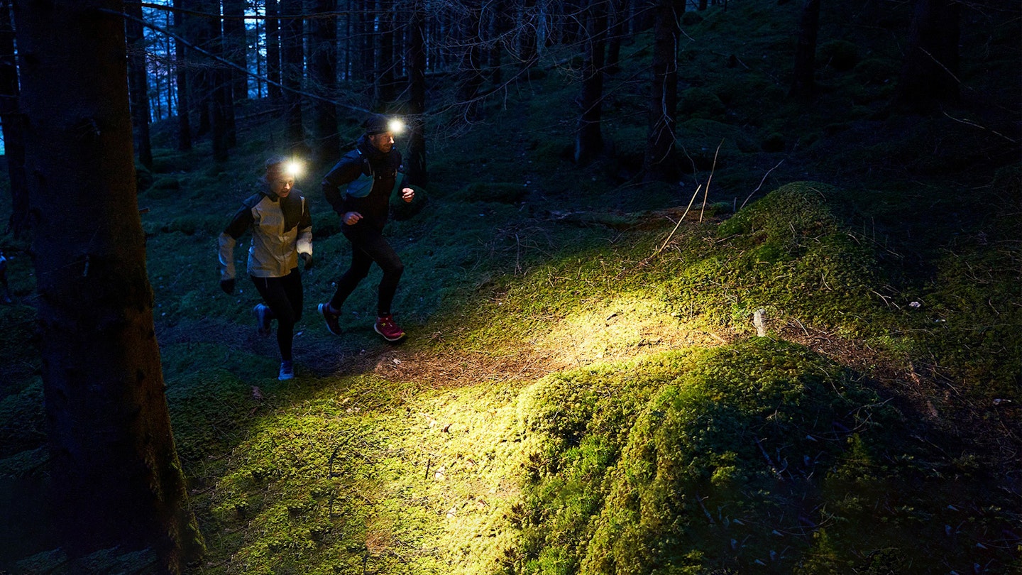Couple trail running in the woods with Fenix headtorches on
