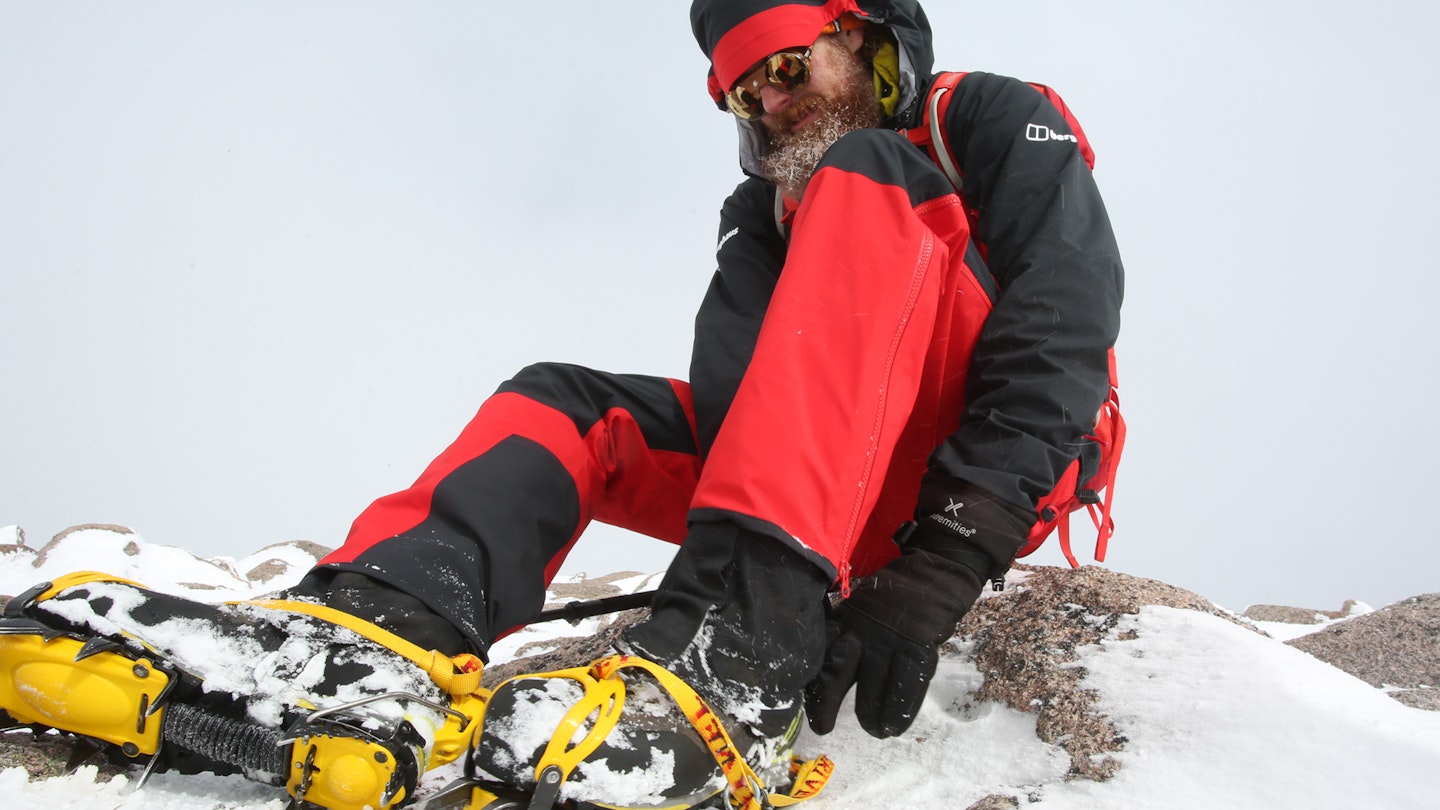 Sitting with crampons in the Berghaus MTN Seeker GTX Pant waterproof overtrousers in snow