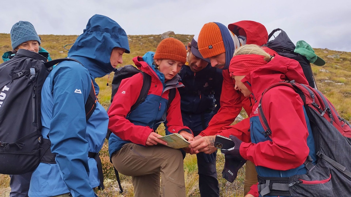 Group of hikers wearing Gore-Tex ePE jackets looking at a map