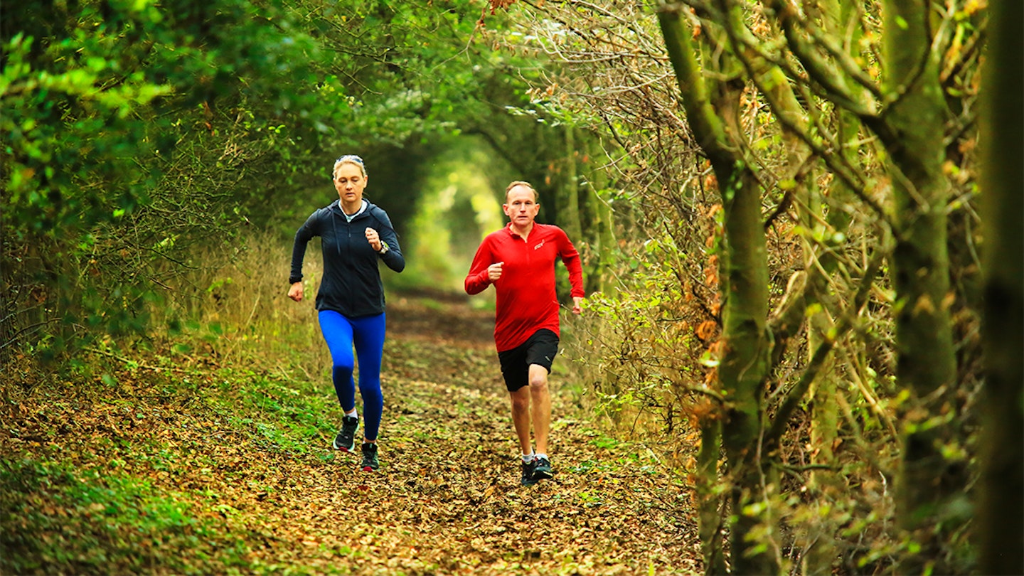 two runners going through a leafy path