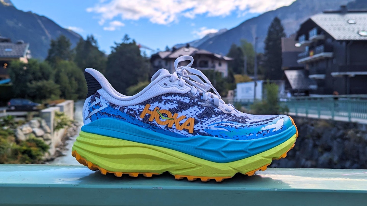 Hoka Stinson 7 profile shot with alpine village in background